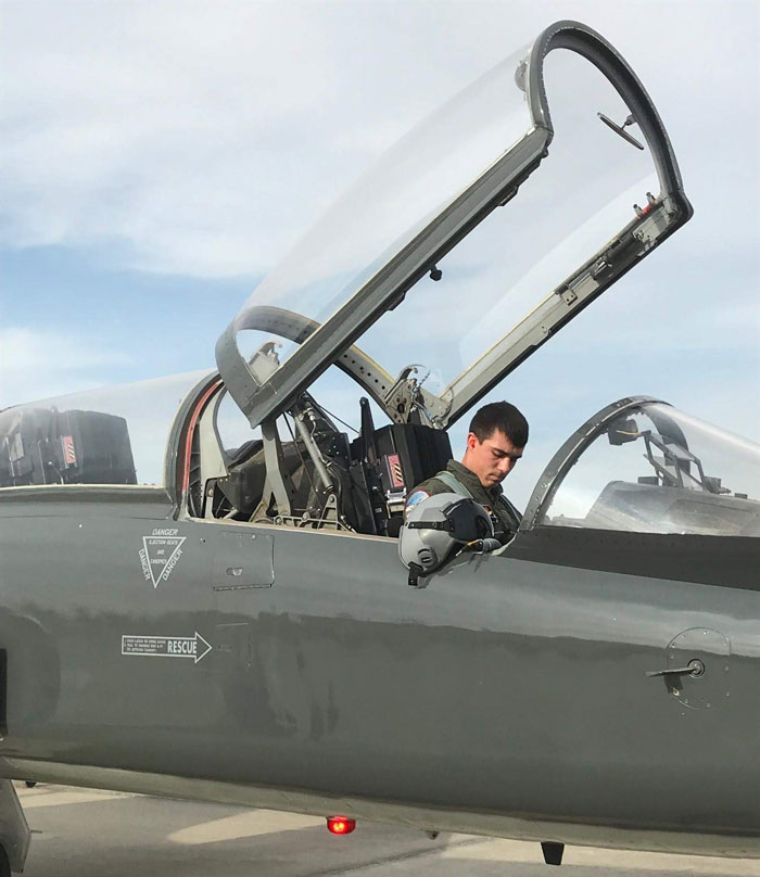 Air Force Pilot sitting in the cockpit of his dark green fighter jet