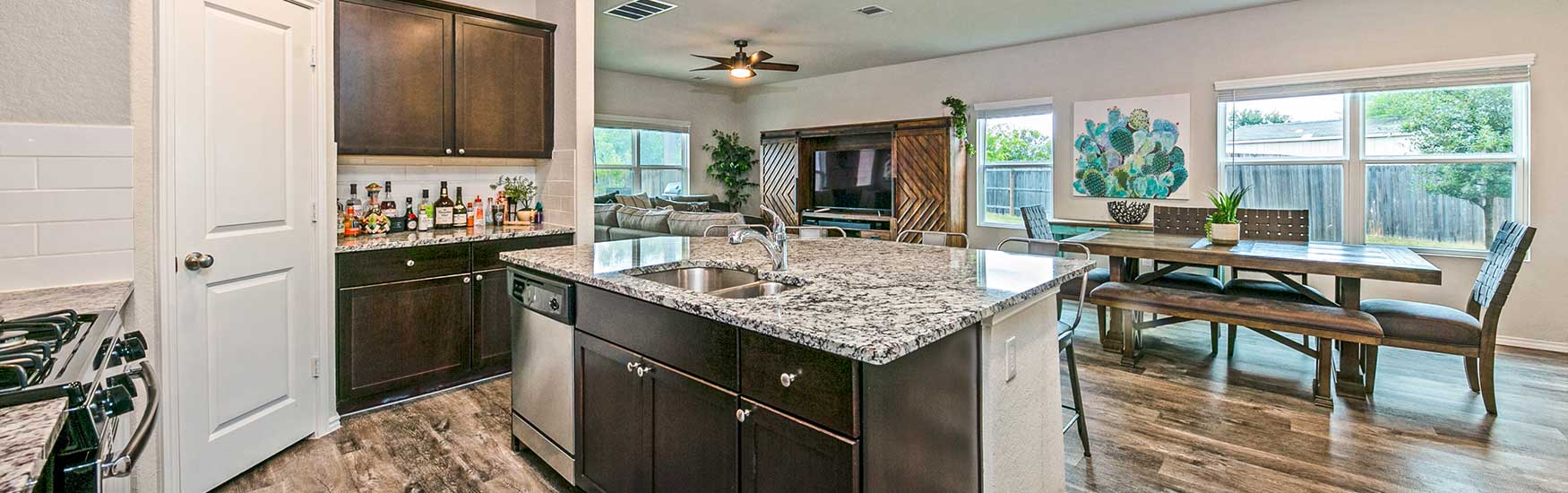 Open kitchen and dining room design with a marble countertop centerpiece available through TDY Haven Crash Pad in Schertz, TX